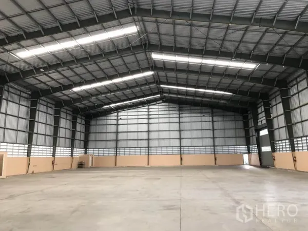 货栈 出租在Pathum Thani - 宽敞的仓库内部，高立柱、明亮灯带照明与大面积空地