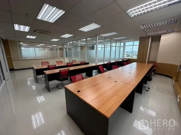 สำนักงาน ให้เช่าในSuan Luang, Bangkok - พื้นที่สำนักงานโอเพ่นแปลน โต๊ะทำงานยาว เก้าอี้สีแดง ผนังกระจกฝ้า และไฟฝ้ากริด