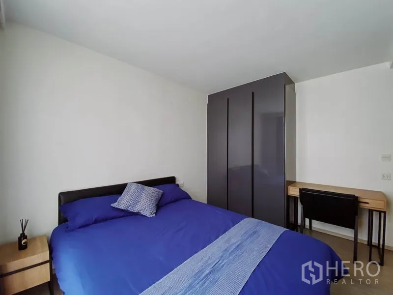 Condominium for rent in Pathum Wan, Bangkok - Master bedroom with wardrobe and study desk positioned opposite the bed.
