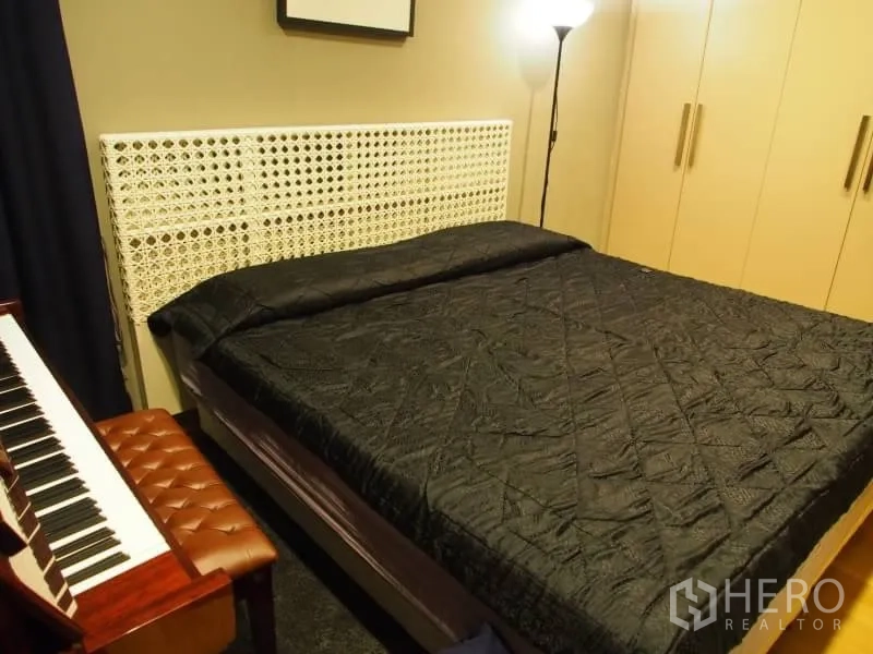 Condominium for rent in Khlong Toei, Bangkok - Cozy master bedroom with king bed, tall wardrobes and a digital piano.