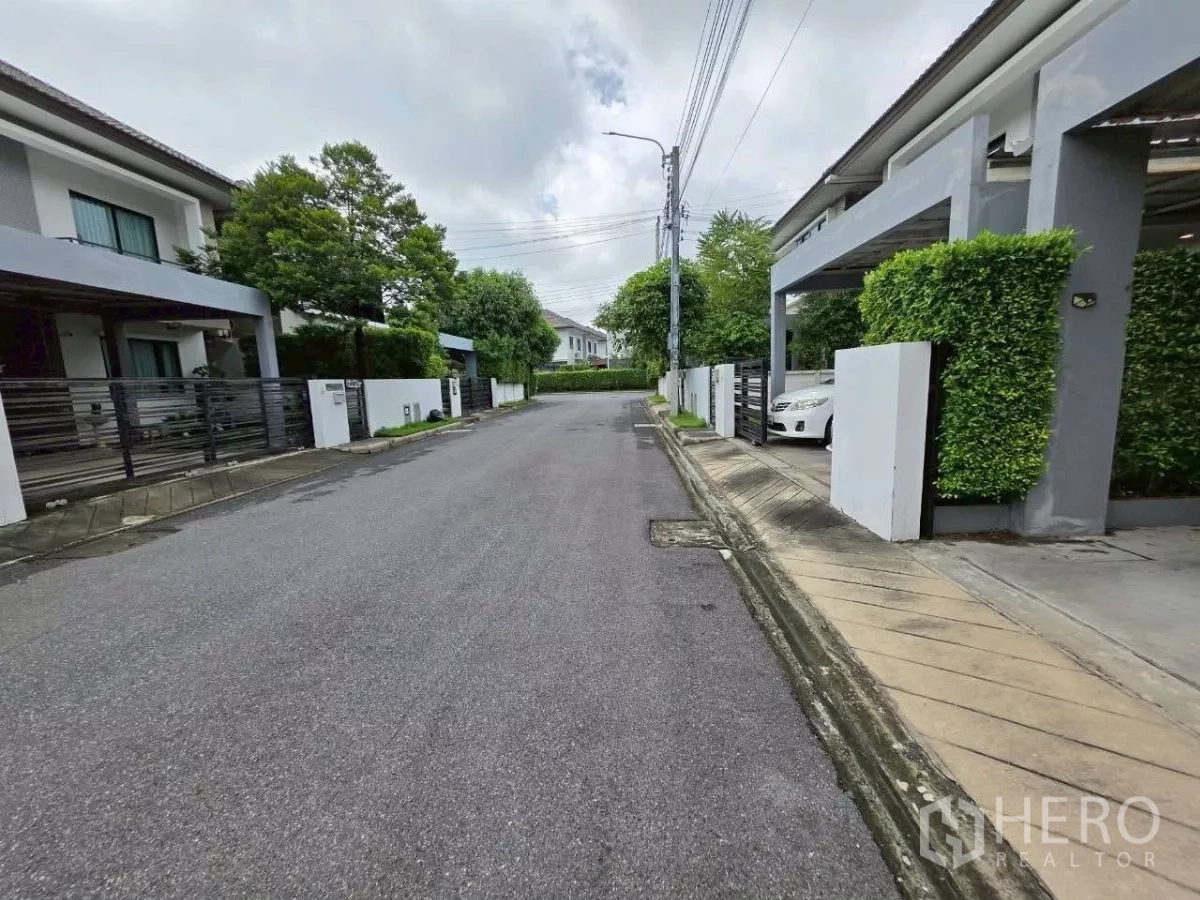 Detached House for rent or sale in Samut Prakan - Quiet residential street inside the gated village with greenery on both sides.
