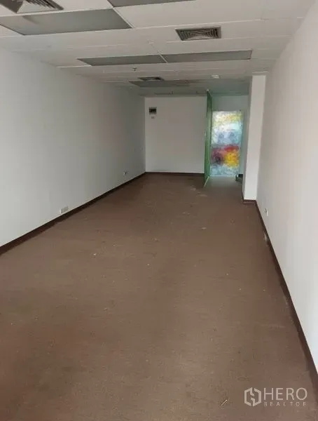 Office Space for rent in Pathum Wan, Bangkok - Long open-plan office with suspended ceiling, air vents, and brown carpet flooring.