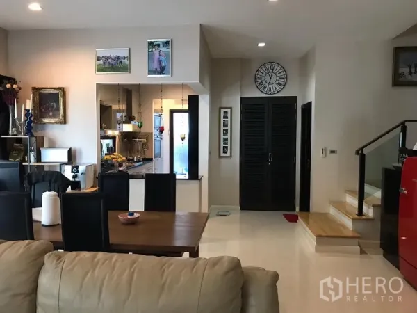 Townhouse for rent or sale in Chatuchak, Bangkok - Open‑plan living and dining area connected to a bright kitchen and staircase.