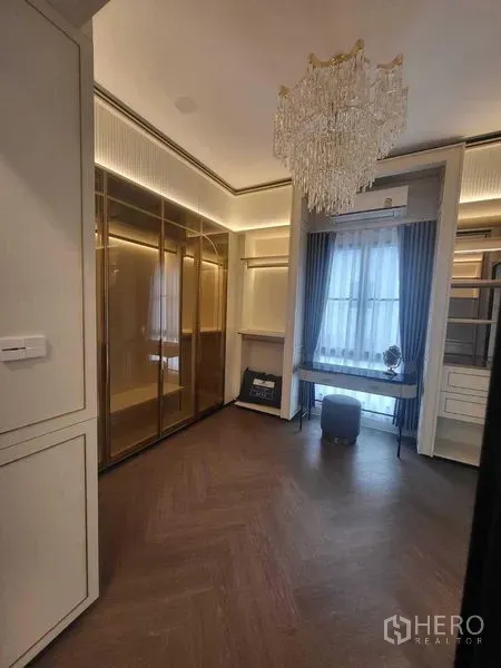 Detached House for rent in Saphan Sung, Bangkok - Walk-in closet with glass wardrobes, chandelier and herringbone wood floor.