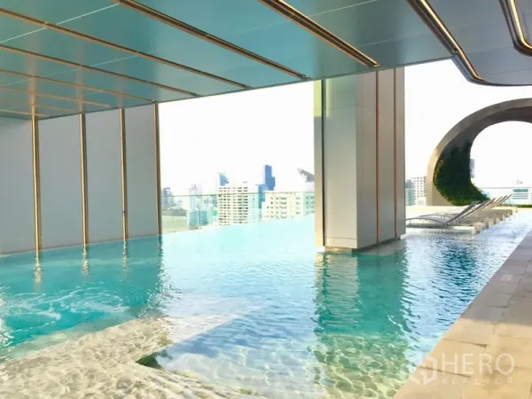 公寓 出租在Watthana, Bangkok - 屋顶无边泳池，配躺椅与城市天际线景观的现代公寓设施。