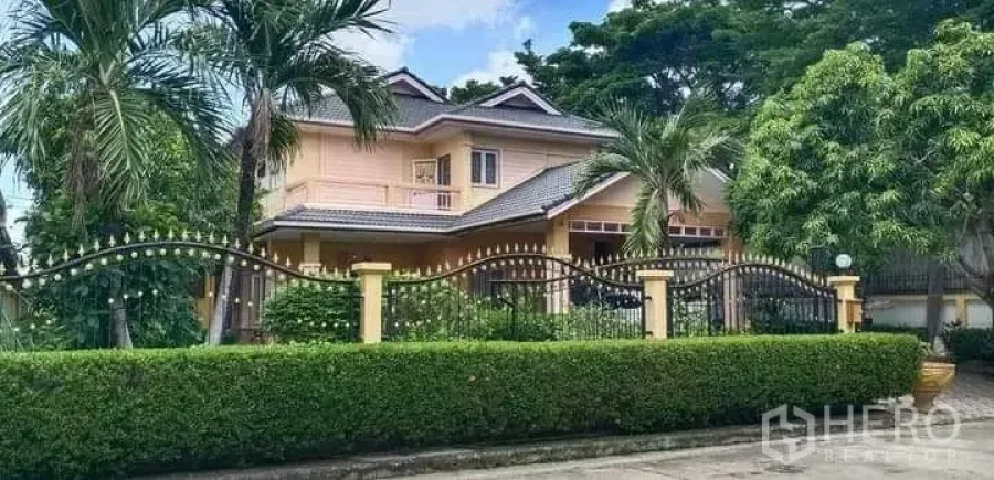 独立式住宅 出售在Prawet, Bangkok - 街景视角的住宅，铁艺围栏与棕榈树