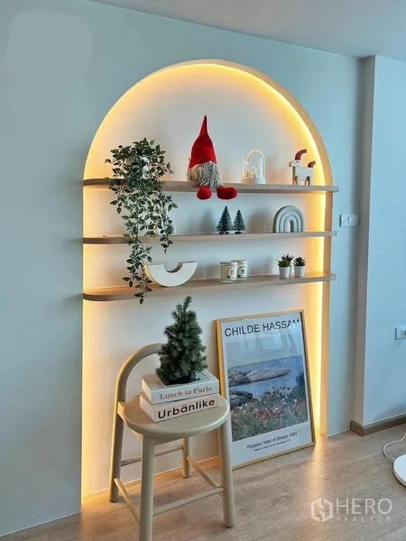 Condominium for rent in Huai Khwang, Bangkok - Arch niche shelving with warm backlighting, decorative plants and art in a modern condo living area.