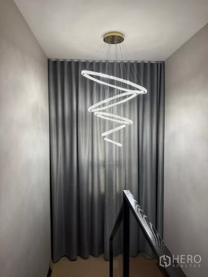 Detached House for rent in Bang Phli, Samut Prakan - Stair landing with a sculptural spiral LED chandelier and grey curtains