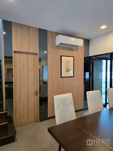 联排别墅 出租在Bang Phli, Samut Prakan - 餐区近景，木质装饰墙、壁挂空调与推拉门。