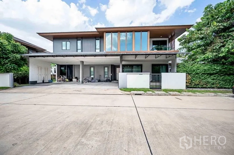 独立式住宅 出售在Prawet, Bangkok - 前立面设宽大车棚与入户小门，街区安静整洁。