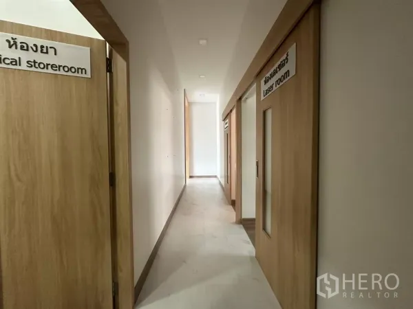 Retail Space for rent in Phra Khanong, Bangkok - Wide corridor with sliding wooden doors leading to treatment rooms and storeroom.
