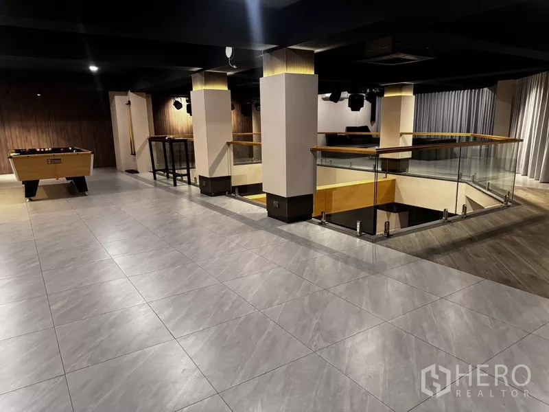 Office Space for rent or sale in Suan Luang, Bangkok - Mezzanine event space with glass balustrade, tiled floor and lounge zones including a games table.
