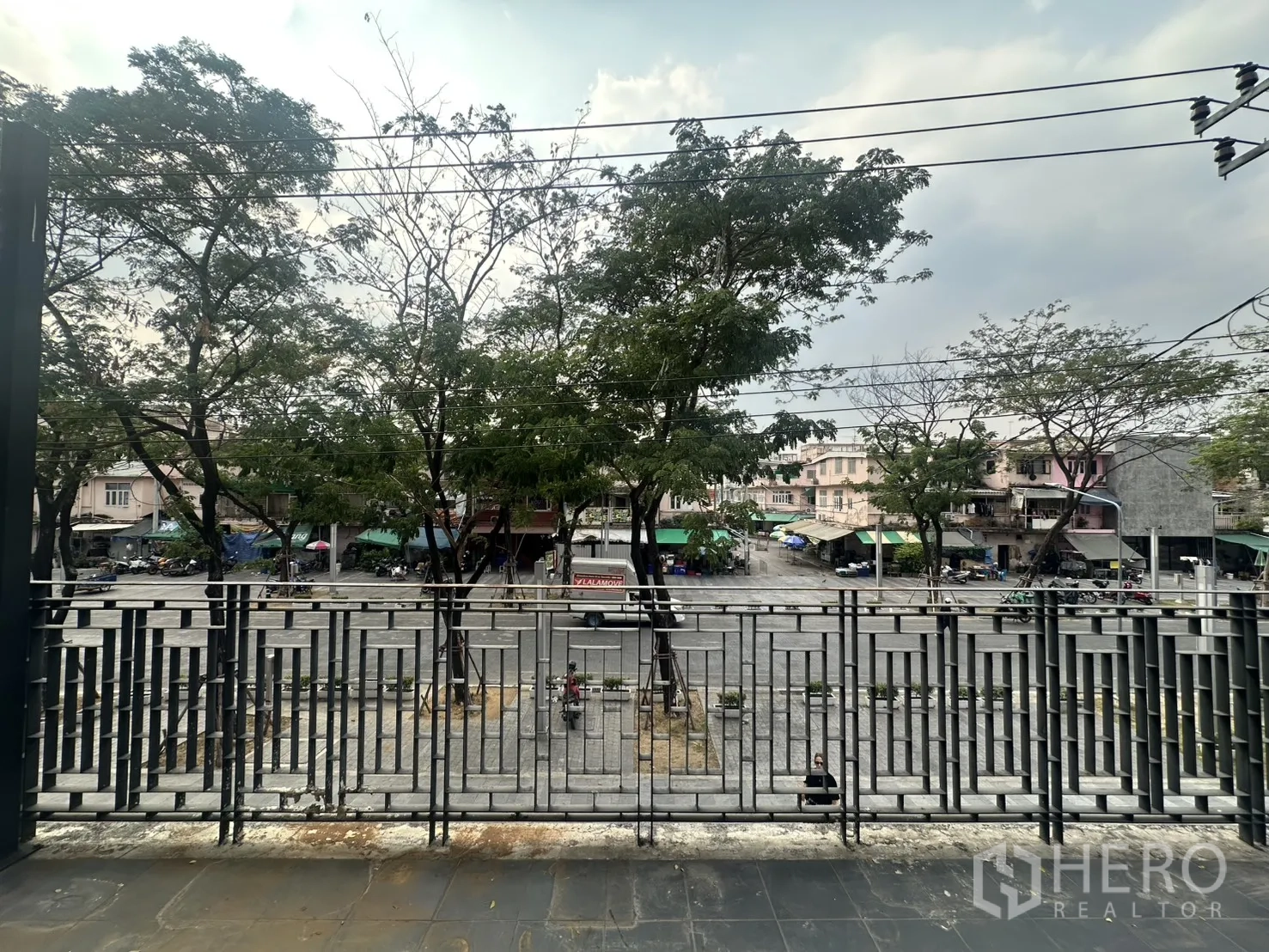 带办公室的家 for rent in Pathum Wan, Bangkok - 阳台面向绿树与广场，配有几何格栅金属栏杆。