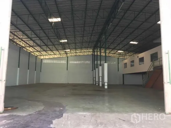 Warehouse for rent in Bang Phli, Samut Prakan - Spacious warehouse interior featuring a high steel-truss ceiling, skylights, and open concrete loading floor.