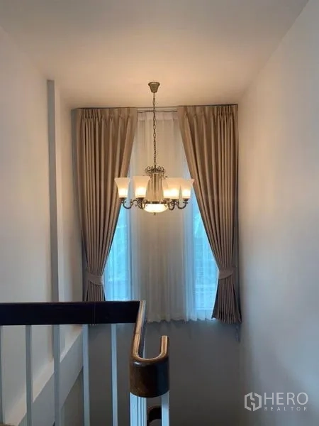 独立式住宅 出租在Ratchathewi, Bangkok - 楼梯间配吊灯和高窗帘。