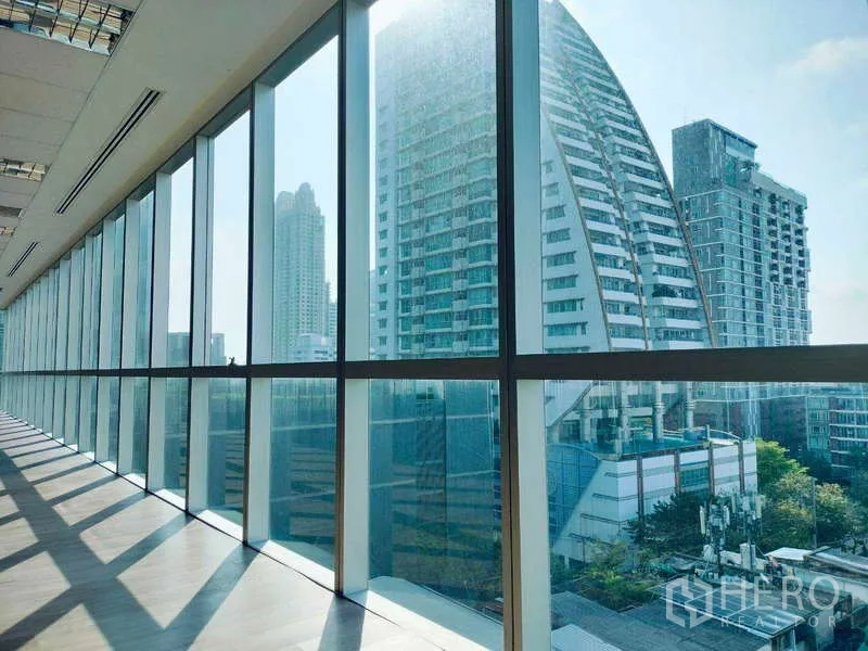 办公空间 出租在Sathon, Bangkok - 通过整面落地玻璃可见现代高楼城市天际线。