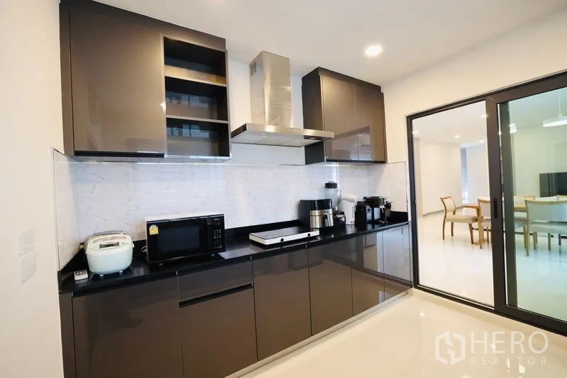 独立式住宅 出租在Bang Phli, Samut Prakan - 现代厨房，亮面橱柜、油烟机与小家电。