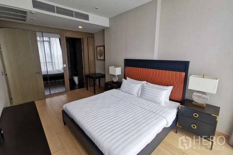 Condominium for rent or sale in Watthana, Bangkok - Second bedroom with orange-panel headboard and ensuite door.