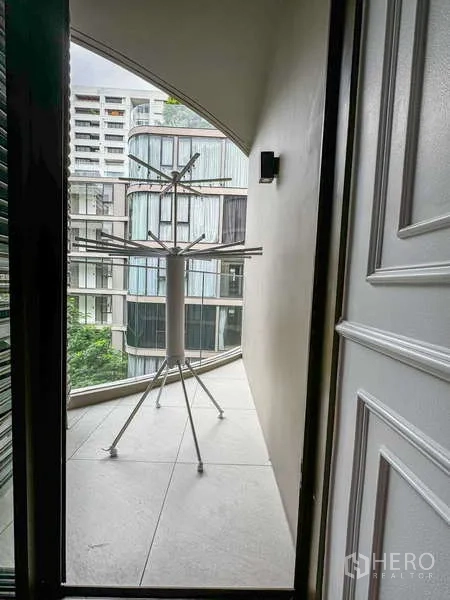 Condominium for rent - Slim balcony with drying rack and view toward neighboring contemporary buildings.