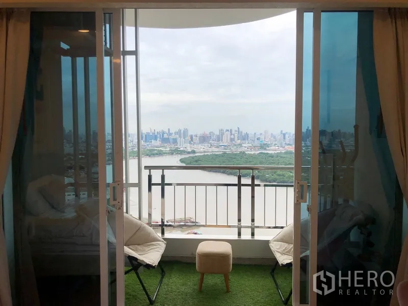 公寓 出售在Yan Nawa, Bangkok - 推拉玻璃门通向阳台，欣赏河景与天际线全景。