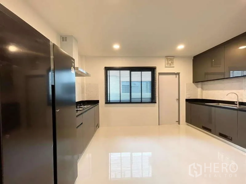 บ้าน ให้เช่าในBang Phli, Samut Prakan - ห้องครัวปิดขนาดใหญ่ ตู้สีเงา เคาน์เตอร์หินสีดำ เครื่องดูดควัน และตู้เย็น