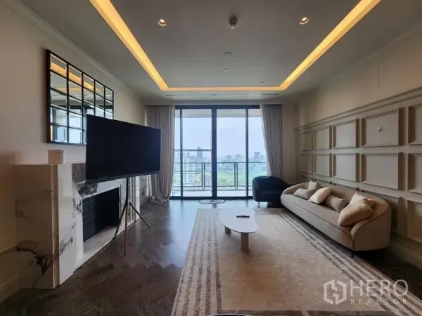 Condominium for sale - Bright living room with marble fireplace, feature wall, large TV, and balcony opening to Bangkok city skyline views.