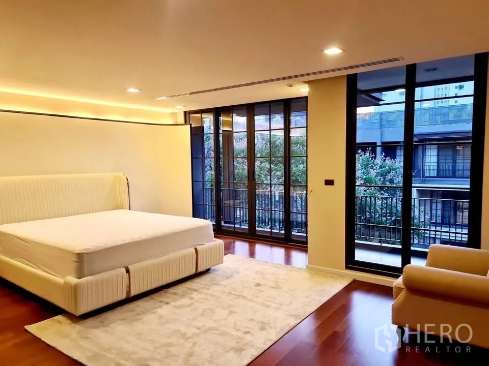 ทาวน์เฮาส์ for rent or sale in Watthana, Bangkok - ห้องนอนกว้างมีผนังกระจกเต็มบานและวิวระเบียง