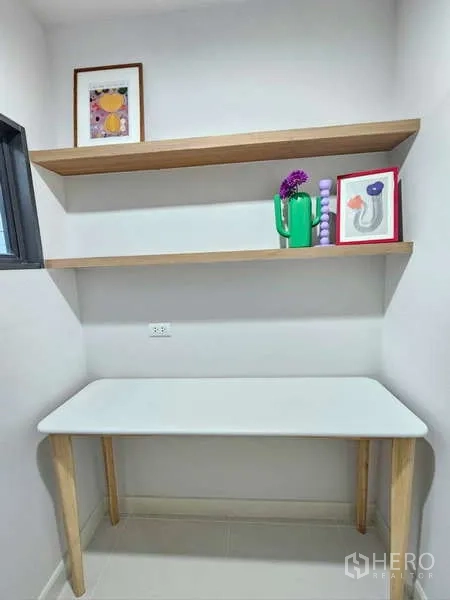 Townhouse for rent in Suan Luang, Bangkok - Small study nook with open shelves and a white desk.