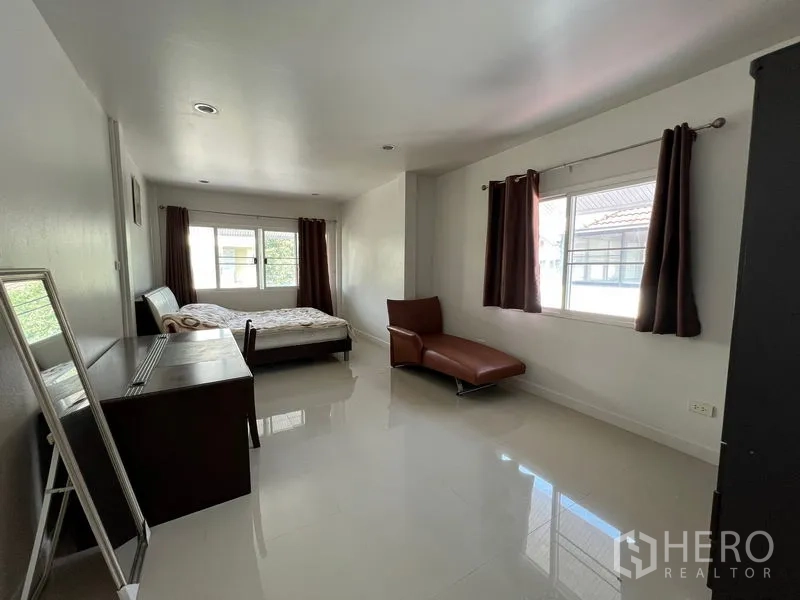 Detached House for rent in Bang Kapi, Bangkok - Long multipurpose bedroom with desk, chaise lounge and two windows.