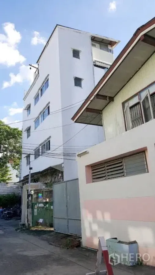 Shophouse for rent - Street view of multi‑storey shophouse facade and metal gate in Phra Khanong.