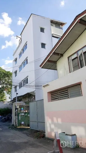 Shophouse for rent - Street view of multi‑storey shophouse facade and metal gate in Phra Khanong.