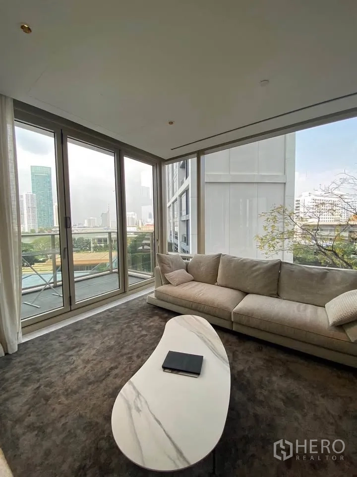 คอนโด for rent in Sathon, Bangkok - ห้องนั่งเล่นมุมอาคาร โซฟาขนาดใหญ่ โต๊ะกลางหินอ่อน และประตูกระจกบานเลื่อน.