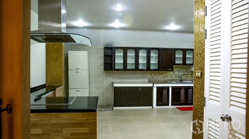 Detached House for rent in Bang Phli, Samut Prakan - Alternate view of the kitchen showing cooktop with hood and extensive storage.