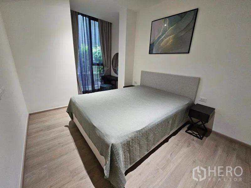 Condominium for rent or sale - Primary bedroom angle showing a desk nook and window with garden view.