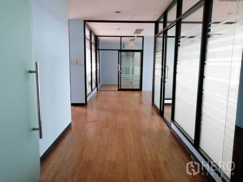办公空间 出租在Bueng Kum, Bangkok - 走廊两侧玻璃隔断与磨砂面板形成多个办公室。