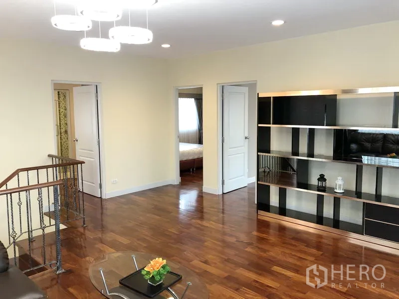 Detached House for rent or sale in Saphan Sung, Bangkok - Upper-floor landing with wood flooring, built-in shelving and doors leading to bedrooms.