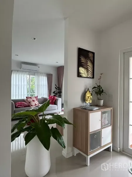 独立式住宅 出租在Prawet, Bangkok - 入户走廊，设装饰柜与绿植，旁有玻璃门。