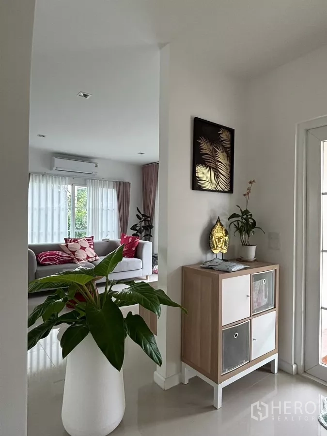 独立式住宅 出租在Prawet, Bangkok - 入户走廊，设装饰柜与绿植，旁有玻璃门。