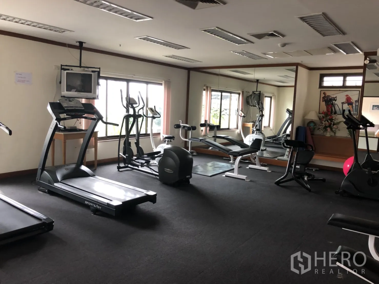 Apartment for rent in Bang Rak, Bangkok - Fitness room with treadmills, elliptical machines, weights and full-wall mirrors with natural light.