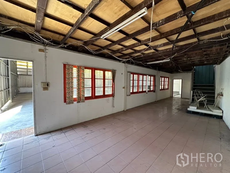 货栈 出租在Suan Luang, Bangkok - 基础办公室，瓷砖地面，裸露木梁天花与红色窗框。