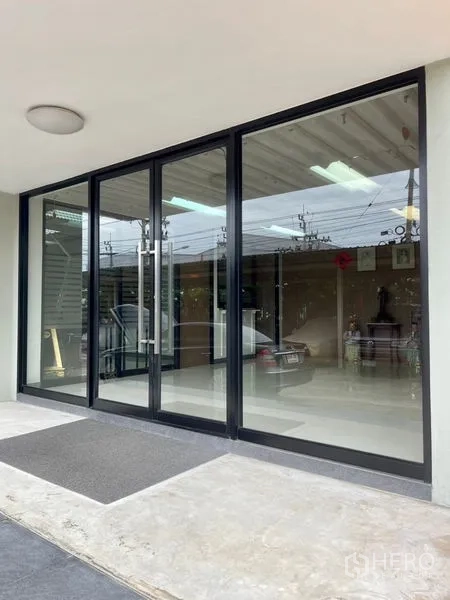 Factory for rent in Mueang Samut Prakan, Samut Prakan - Glass sliding entrance doors opening to showroom or office