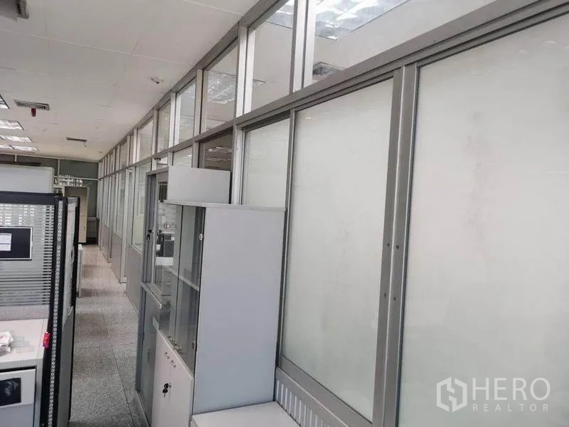 办公空间 出租在Bang Na, Bangkok - 办公室走廊，两侧为磨砂玻璃隔断与储物柜。