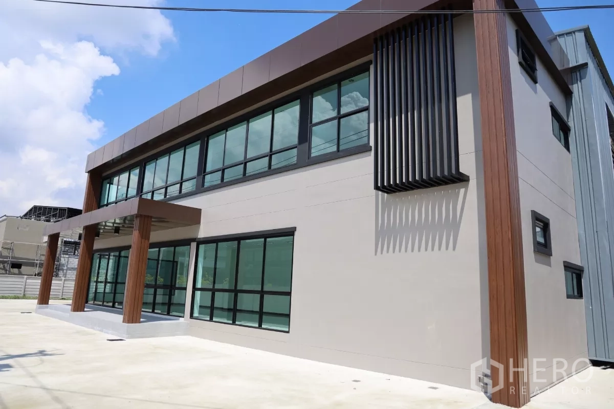 工厂 出租或出售在Bang Len, Nakhon Pathom - 侧立面展示竖向遮阳与大面积玻璃的现代办公室设计。