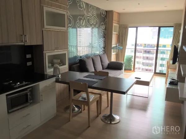 公寓 出租在Bangkok - 开放式客餐厅，厨房、餐桌、沙发与可观景的阳台。