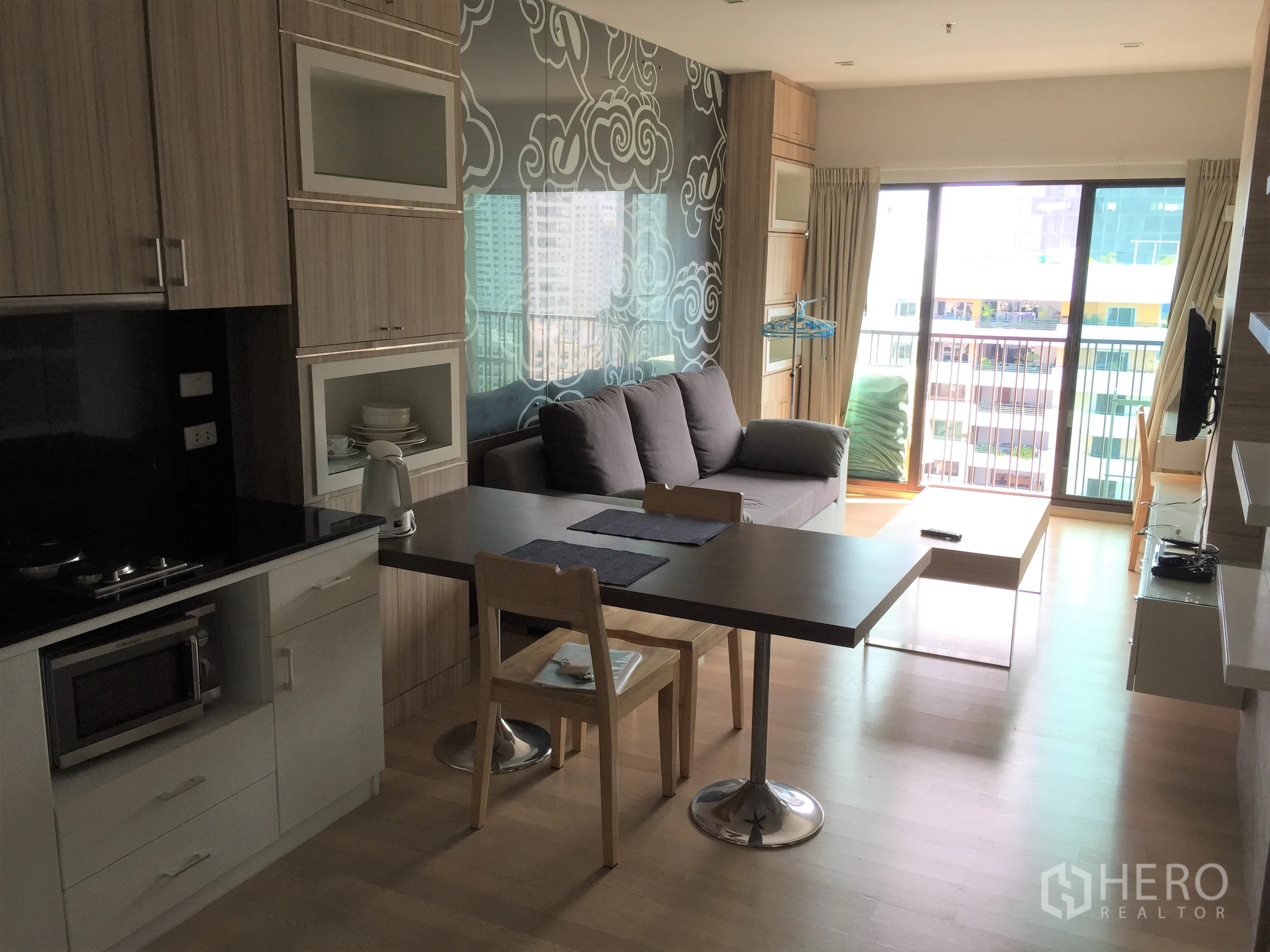 公寓 出租在Bangkok - 开放式客餐厅，厨房、餐桌、沙发与可观景的阳台。