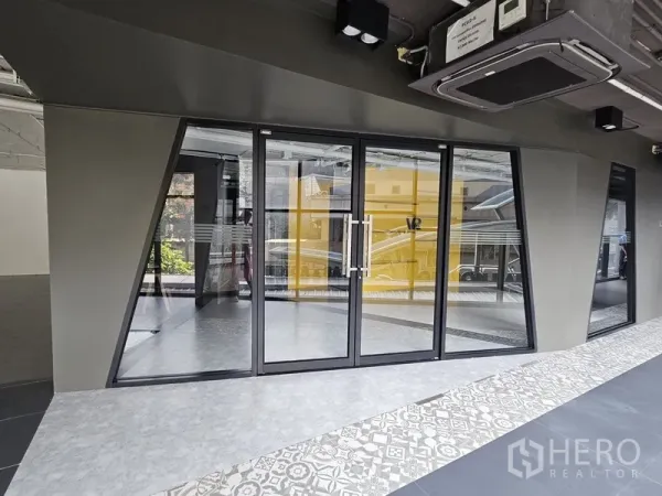 Retail Space for rent - Ground-floor storefront with double glass doors and patterned tile walkway outside.