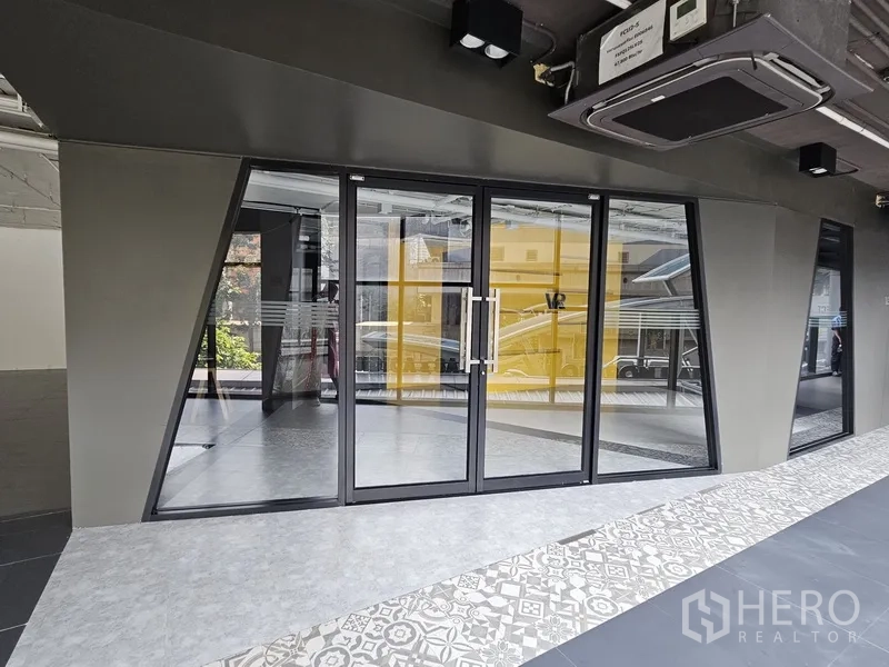 Retail Space for rent - Ground-floor storefront with double glass doors and patterned tile walkway outside.