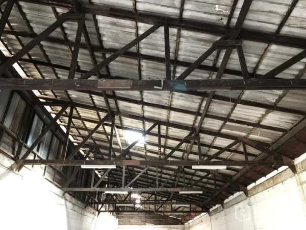 零售空间 出租在Khlong Toei, Bangkok - 金属屋顶与外露钢桁架特写，配有条形照明，层高开阔。