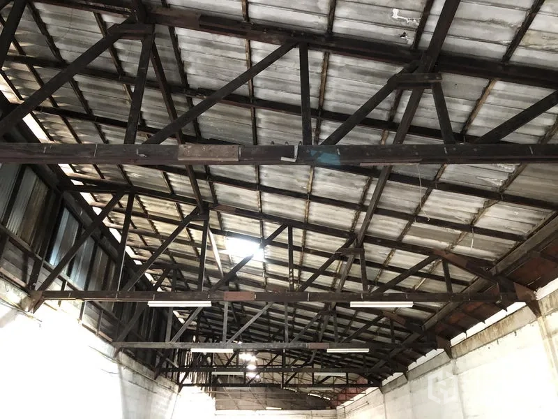 零售空间 出租在Khlong Toei, Bangkok - 金属屋顶与外露钢桁架特写，配有条形照明，层高开阔。