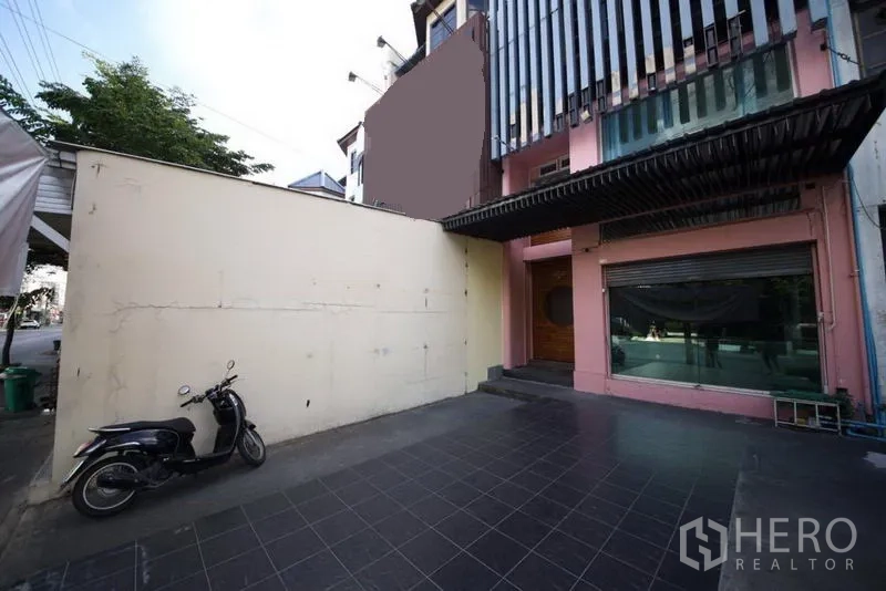 带办公室的家 出租或出售在Huai Khwang, Bangkok - 曼谷Huai Khwang区带铺装停车庭院与玻璃立面的商住两用屋正面。
